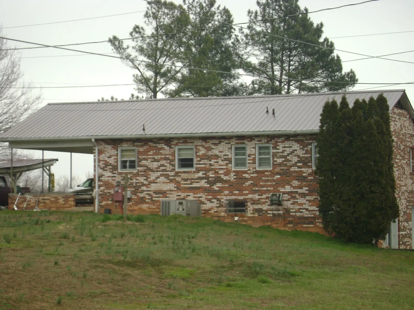 Gray metal roof on a brick split level home with a carport in Centreville